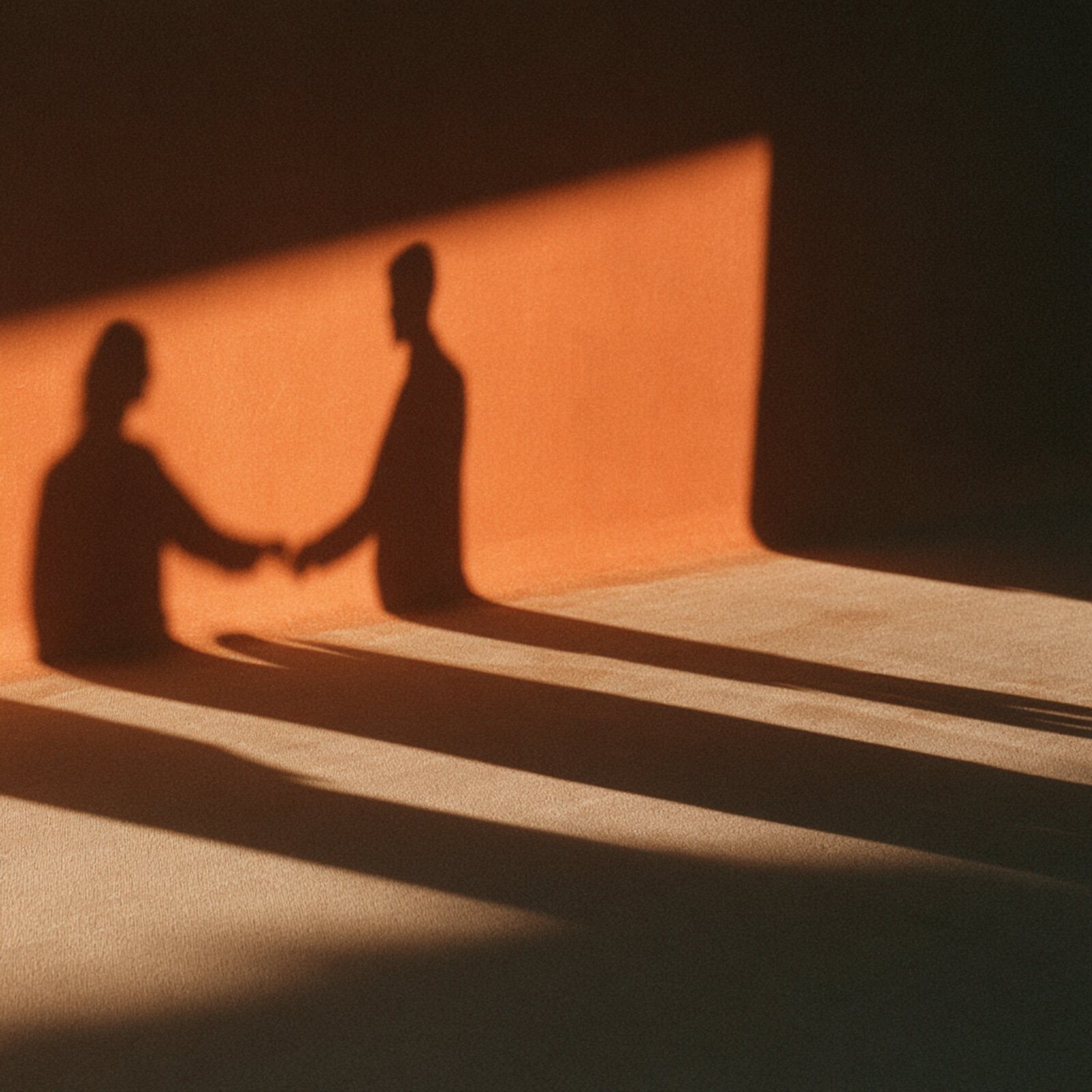 Two figures in silhouette, one passing something to the other